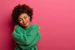 A woman hugging herself.