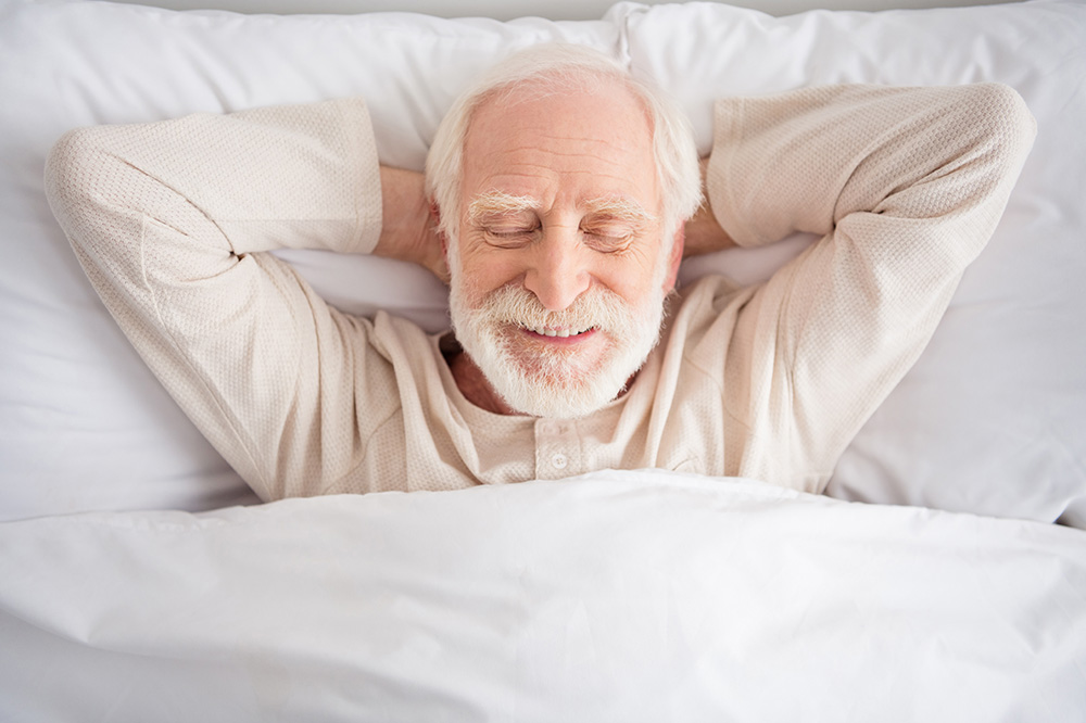 A man in bed, sleeping.