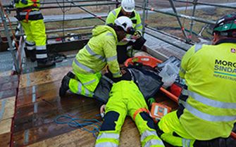 A construction worker performing CPR on his colleague. A construction worker performing CPR on his colleague.