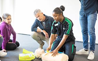 A St John Ambulance trainer demonstrating first aid skills to a group of learners. A St John Ambulance trainer demonstrating first aid skills to a group of learners.