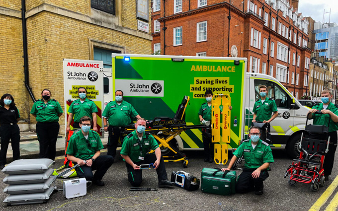 A group of St John Ambulance volunteers in front of an ambulance with all of their supplies.