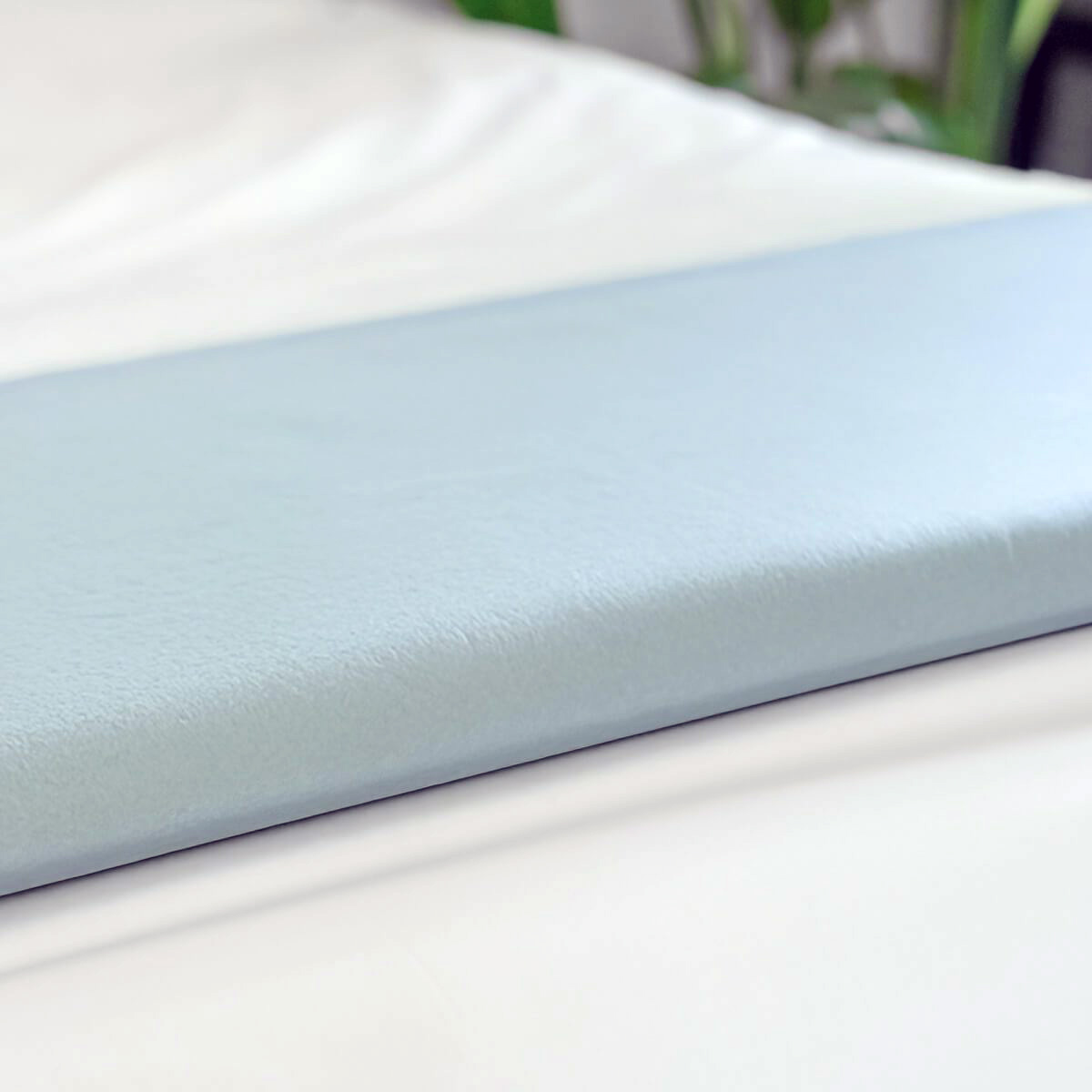 A practical use of the Interweave Single Use Fleece Blanket, folded on top a bed.