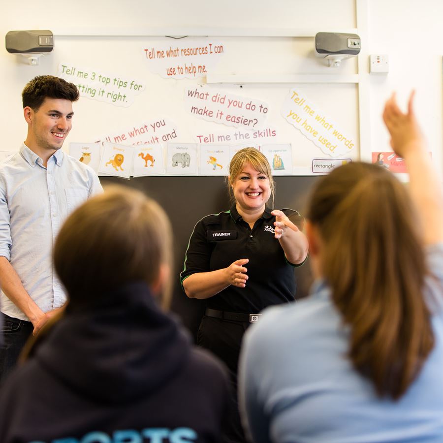 A St John Ambulance trainer teaching a class of pupils first aid