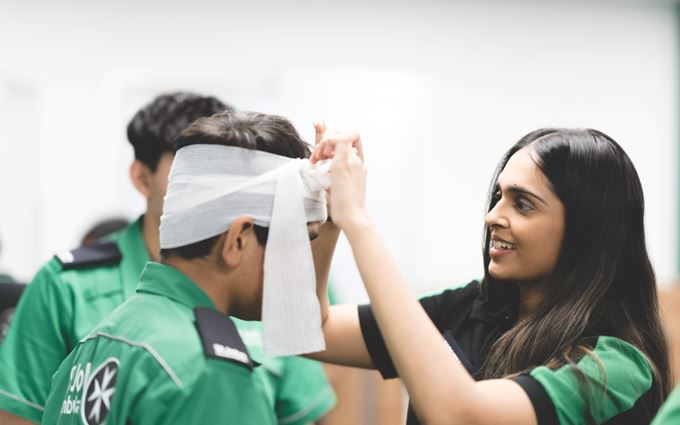 Youth team volunteer bandaging a Cadet's head Youth team volunteer bandaging a Cadet's head