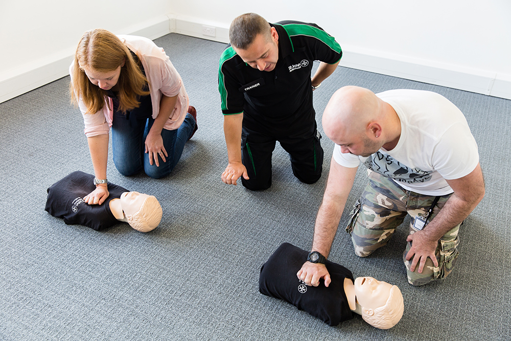 St John Ambulance trainer teaches participants child CPR