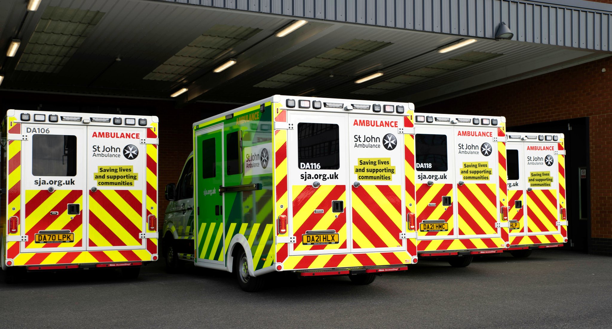 rear doors of 4 St John Ambulance ambulances parked in a row