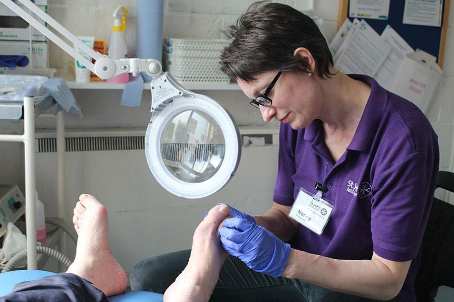Podiatrist examining a service user's feet