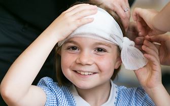 School child with bandage on head
