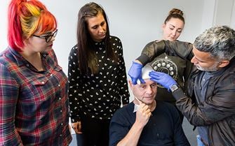 First aid course participants applying a head bandage First aid course participants applying a head bandage