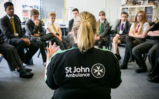 St John Ambulance trainer teaching a class of school children first aid St John Ambulance trainer teaching a class of school children first aid