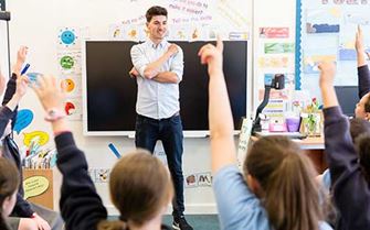School teacher teaching classroom of children
